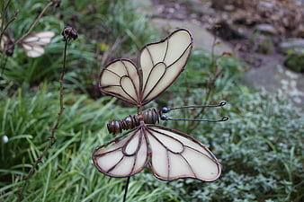 Metal wire butterfly garden stake in green foliage