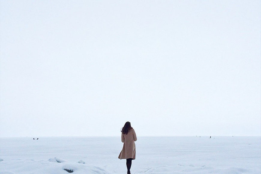 Woman in Beige Coat Walking Alone in Snowy Landscape