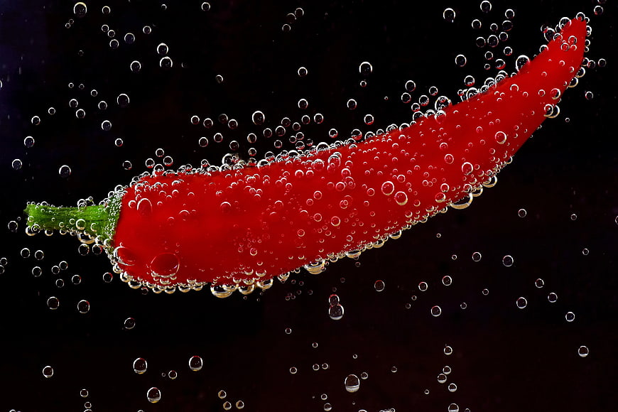 Red Chili Pepper Submerged in Water with Bubbles