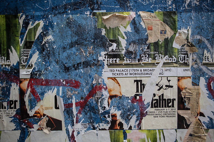 Torn Posters and Blue Graffiti on Urban Wall