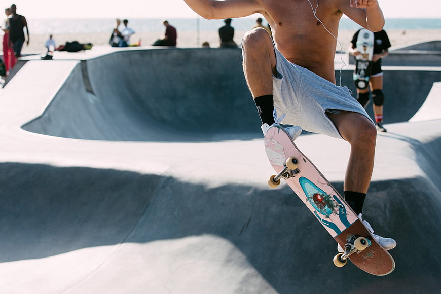 Skateboarder performing trick at sunny outdoor skate park