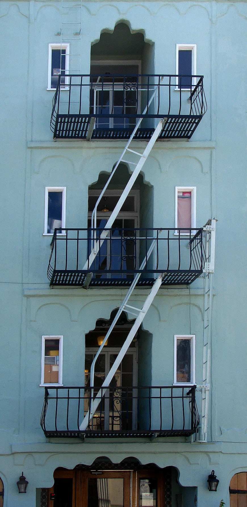 Blue building facade with white fire escape ladder