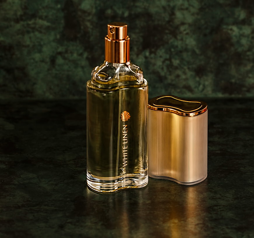 Luxury White Linen Perfume Bottle With Gold Cap On Dark Green Background