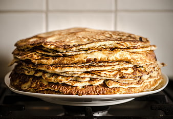 Stack of Golden Brown Pancakes on White Plate in Kitchen