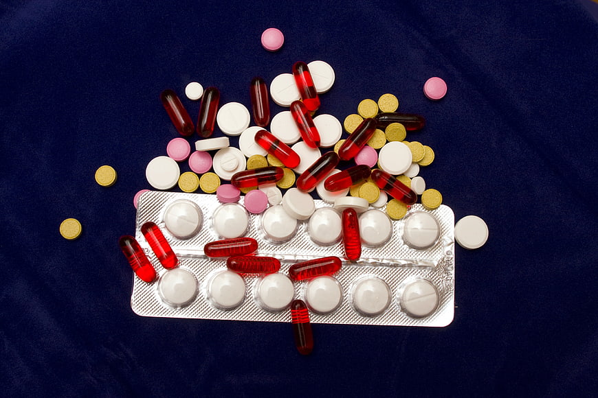 Assorted pills and capsules on blue background