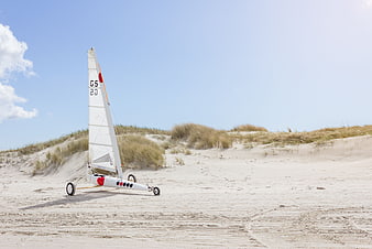 Land yacht on sandy dunes under blue sky