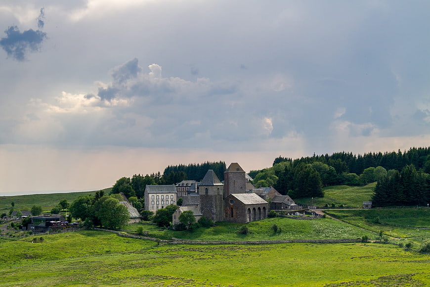 Historic Abbey in Green Valley Under Dramatic Clouds