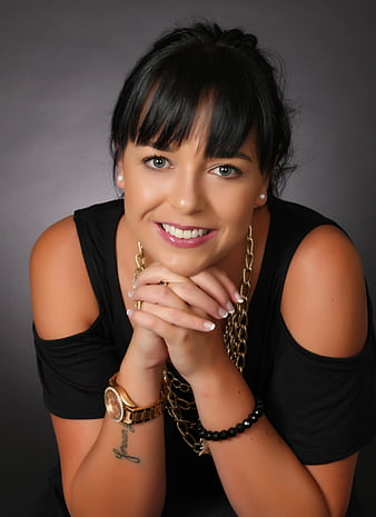 Portrait of Smiling Woman with Bangs and Gold Jewelry