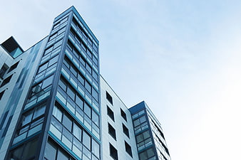 Low angle view of modern glass and steel architecture against blue sky