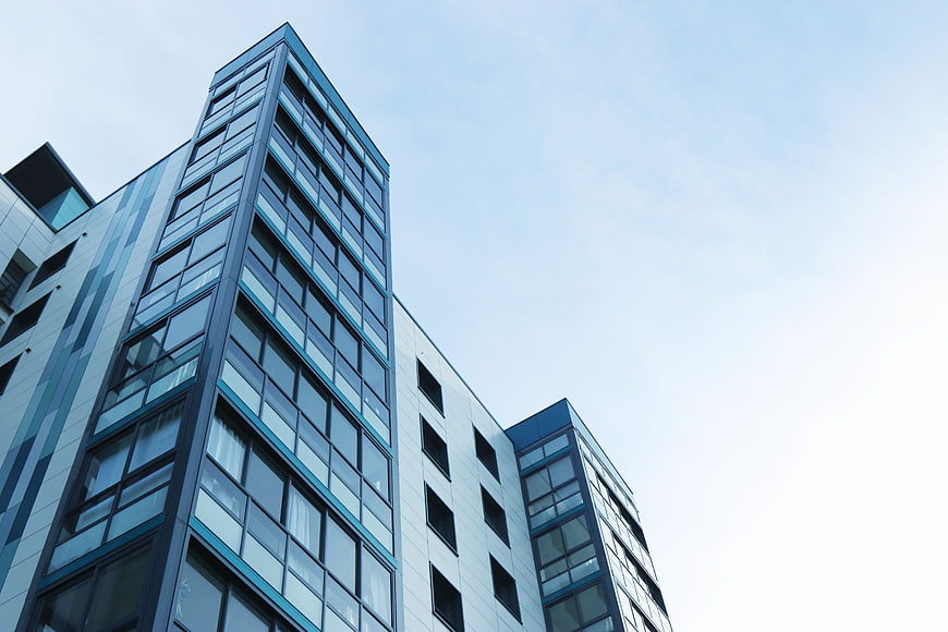 Low angle view of modern glass and steel architecture against blue sky