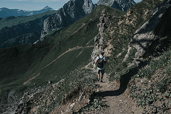 Hiker Walking on Mountain Trail in Swiss Alps