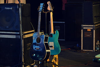 Acoustic and Electric Guitars on Stage with Amplifiers