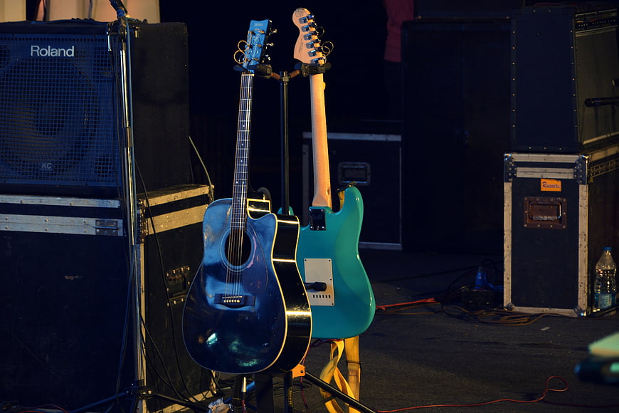 Acoustic and Electric Guitars on Stage with Amplifiers