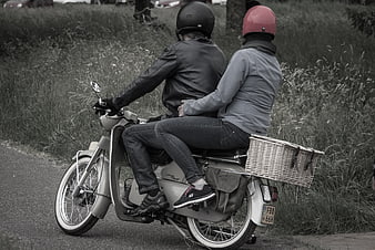 Couple Riding Vintage Scooter with Red Helmet