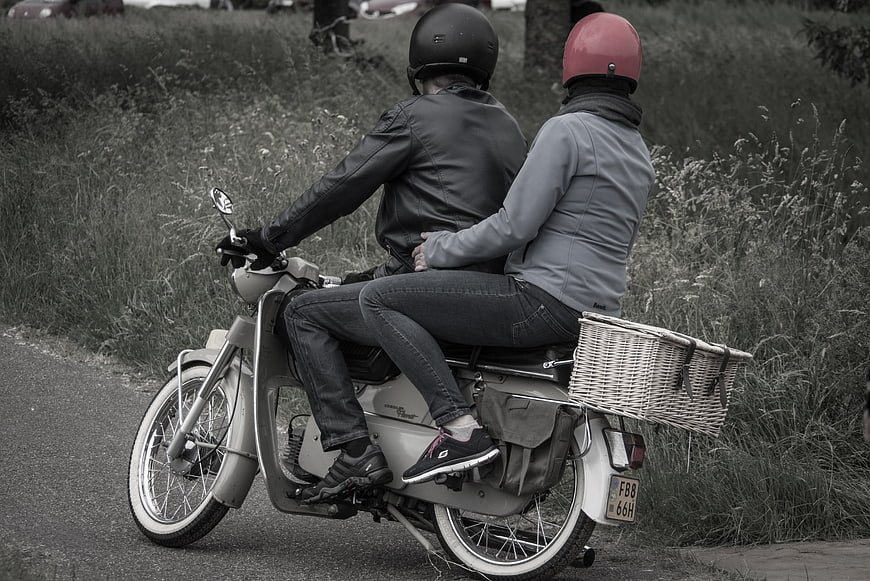 Couple Riding Vintage Scooter with Red Helmet