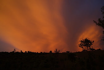 Dramatic orange sunset sky over silhouetted landscape