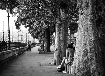 Black and white couple sitting on bench under trees in Budapest