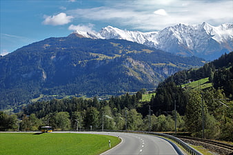 Alpine Landscape With Snow-Capped Peaks And Winding Road