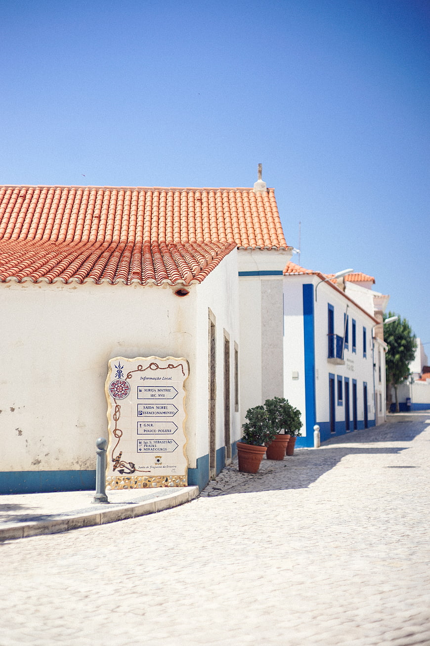 Sunny cobblestone street in Portuguese village with white buildings