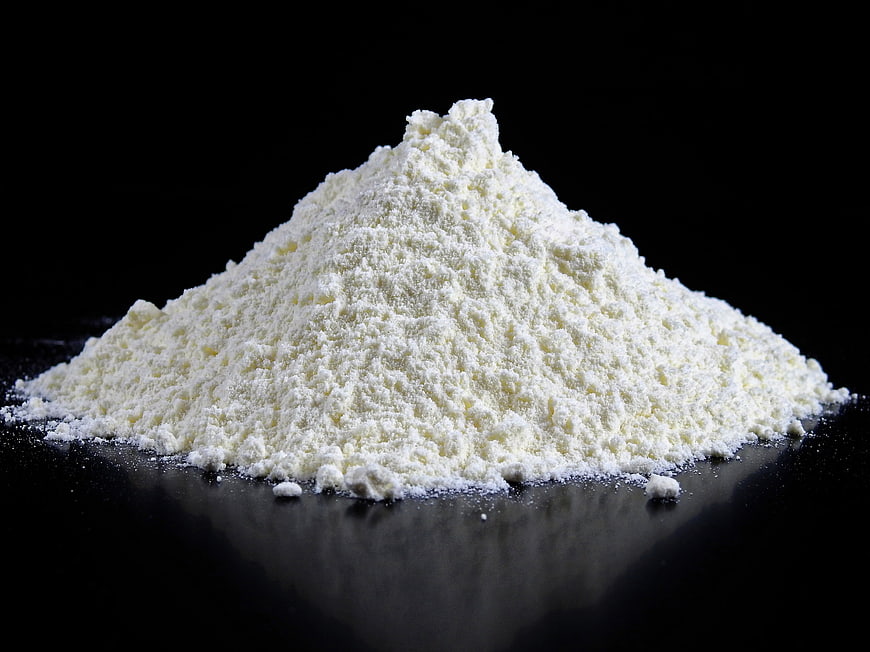Pile of white flour on black background