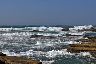 Rough ocean waves crashing on rocky coastal shelves
