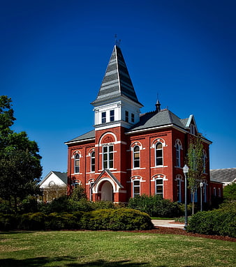 Red Brick Historic Building with Steeple Against Blue Sky