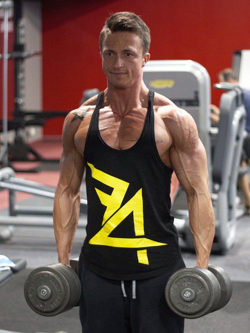 Muscular man lifting dumbbells in gym