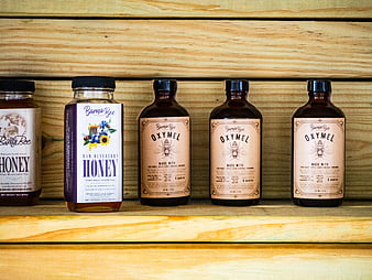 Artisanal Honey and Oxymel Bottles on Wooden Shelf