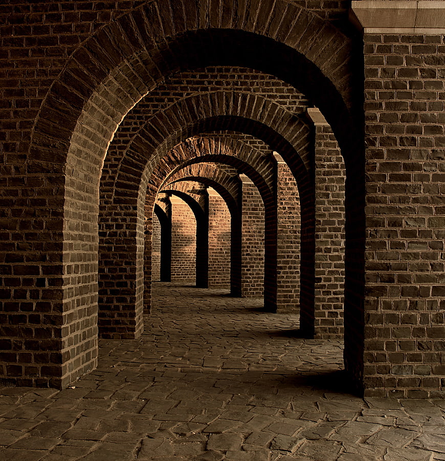Dark brick archway corridor with stone floor