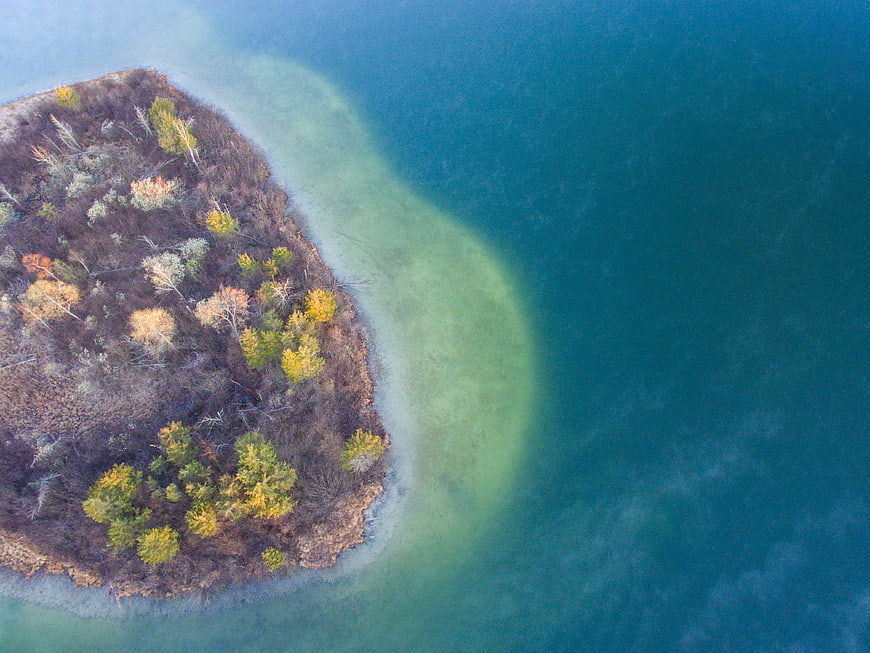 Aerial View of Forested Island in Autumn Waters
