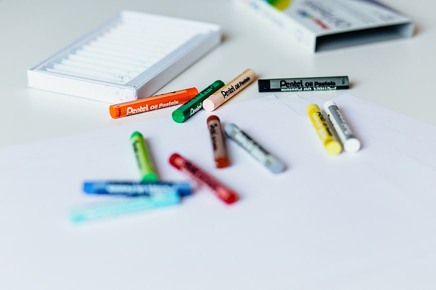 Colorful Pentel Oil Pastels Scattered on White Paper