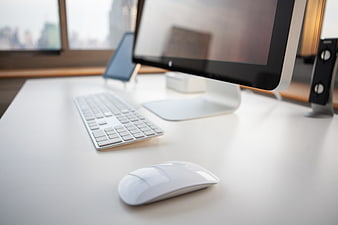 Modern minimalist white workspace with computer and keyboard