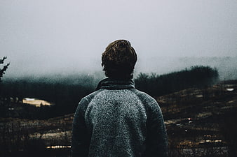 Man Looking Out at Foggy Highland Landscape