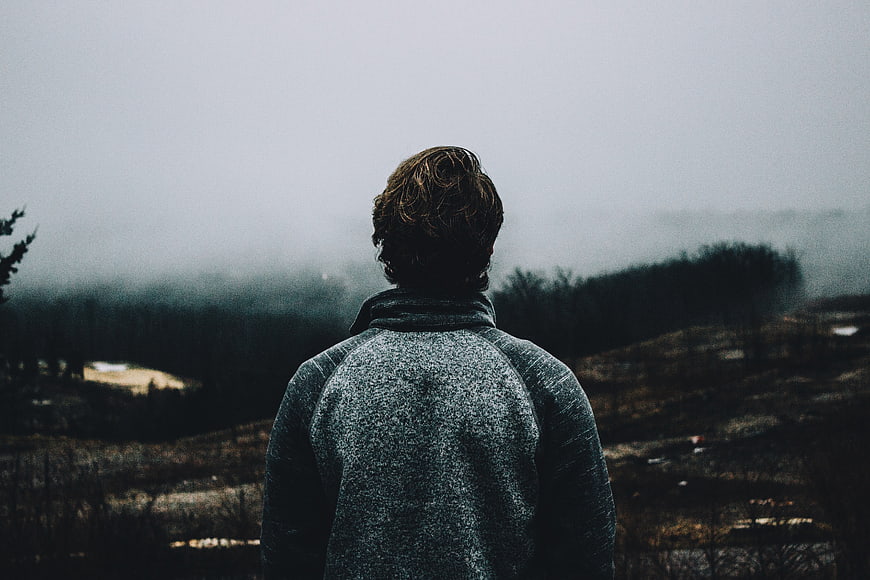 Man Looking Out at Foggy Highland Landscape