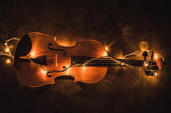 Violin Wrapped in Warm Fairy Lights on Dark Background