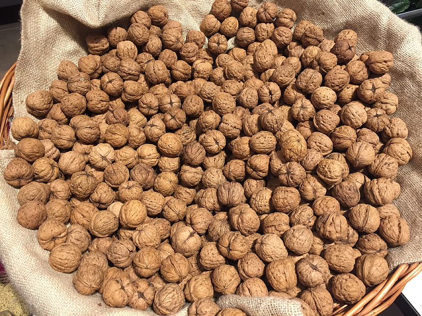Pile of raw walnuts in a burlap sack