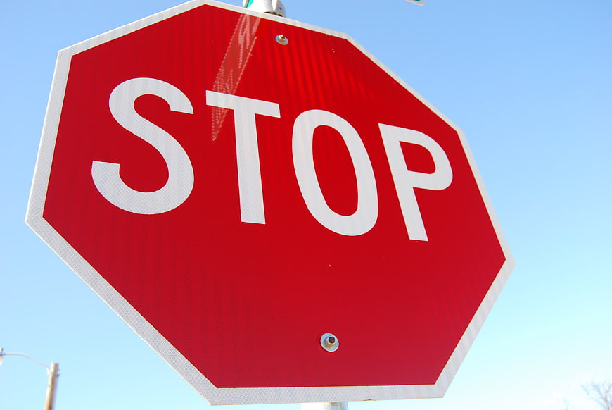 Red Stop Sign Against Blue Sky