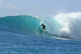 Surfer Riding Inside a Perfect Blue Barrel Wave