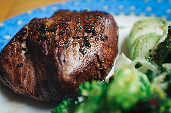 Close-up of grilled beef steak with black salt and broccoli