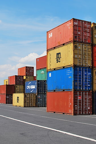 Stacked Shipping Containers at Port with Blue Sky