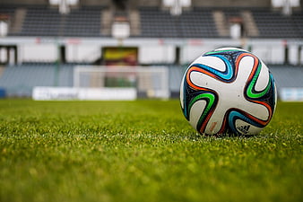 Soccer ball on grass in empty stadium