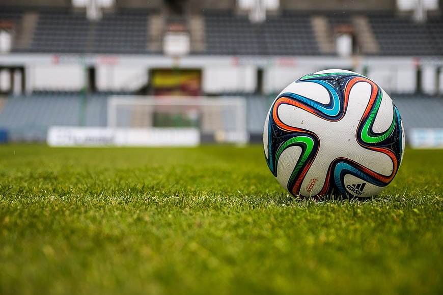 Soccer ball on grass in empty stadium