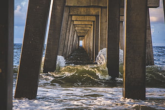 Perspective view under pier with crashing ocean waves