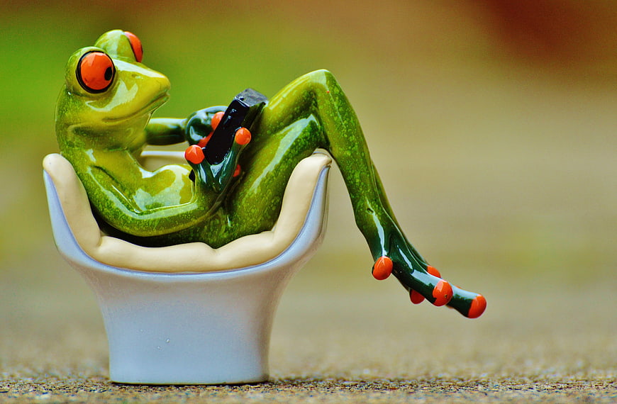 Cute Ceramic Frog Figurine Relaxing In Chair With Tablet