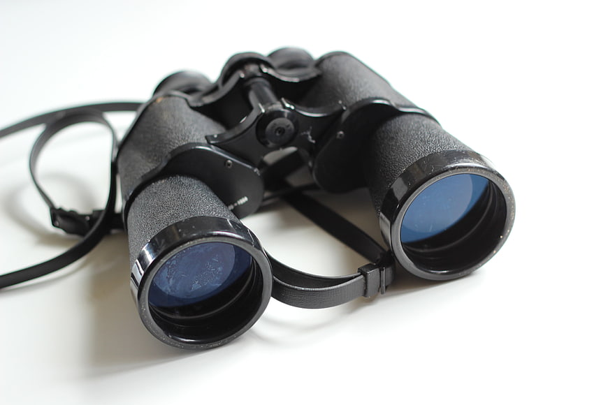 Vintage black binoculars on white background