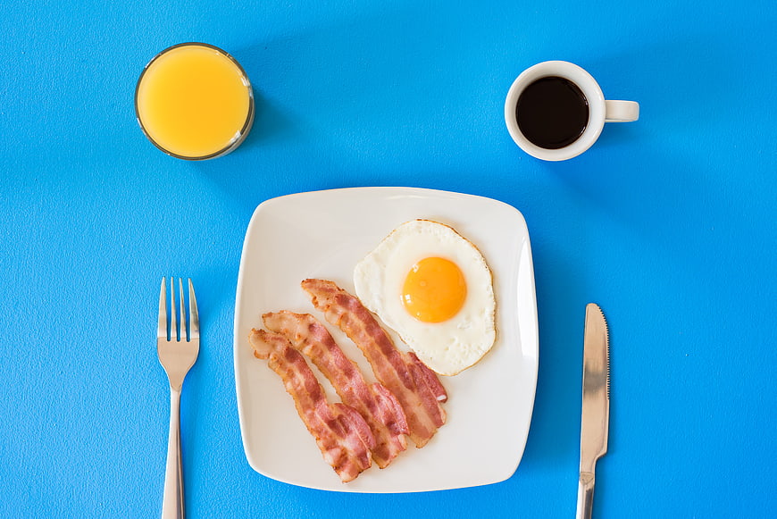Top View of Classic Breakfast with Bacon, Eggs, Coffee, and Juice
