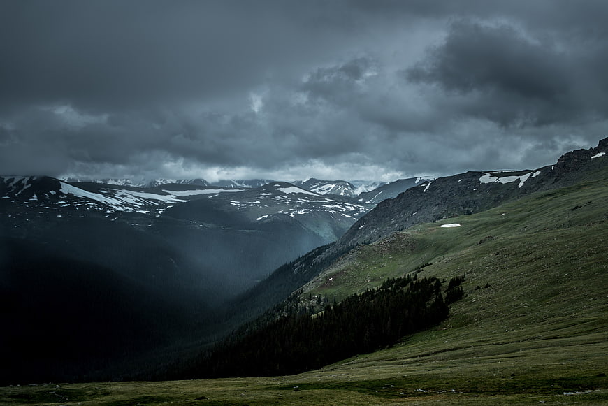 Dramatic Stormy Mountain Landscape with Snow and Green Slopes