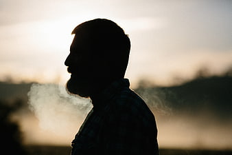 Silhouette of Man Smoking in Cold Morning Mist