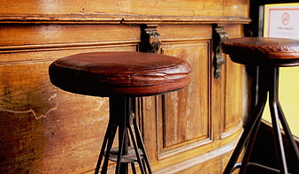 Vintage Leather Bar Stools Against Wooden Paneling