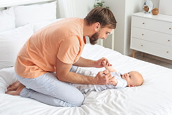 Father Playing with Baby on White Bed